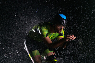 A triathlete braving the rain as he cycles through the night, preparing himself for the upcoming...