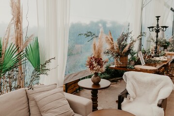 A festive outdoor event set up for a celebration, with a white tent, assorted tables and chairs