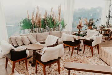 Festive outdoor event set up for a celebration, with a white tent, assorted tables and chairs