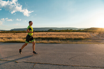 Triathlete in professional gear running early in the morning, preparing for a marathon, dedication to sport and readiness to take on the challenges of a marathon. 