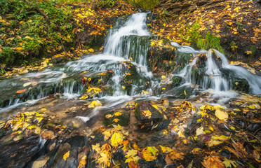 Beautiful waterfall during autumn leaf fall