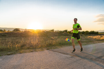 Obraz premium Triathlete in professional gear running early in the morning, preparing for a marathon, dedication to sport and readiness to take on the challenges of a marathon. 
