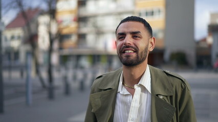 One happy young Middle Eastern man standing in city street smiling with confidence. Portrait of an Arab male person