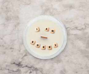 Apology. Phrase I Am Sorry of wooden cubes in candle on white marble table, top view