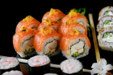 Sushi set on a black background. Fresh variety of rolls in a Japanese restaurant. Eastern cuisine.