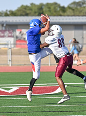 Young athletic young boys playing in a competitive game of tackle football and making incredible game winning plays