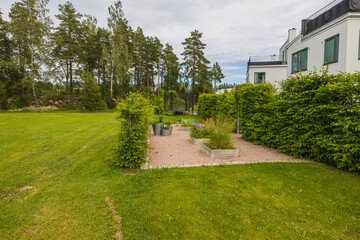 Beautiful green nature landscape view. While modern houses with green bushes and trees on backyard. Sweden. 