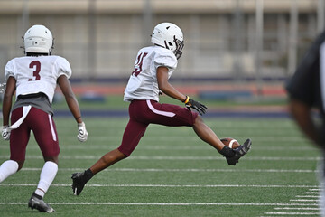 Young athletic young boys playing in a competitive game of tackle football and making incredible...
