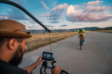 A videographer recording a triathlete riding his bike preparing for an upcoming marathon.Athlete's...