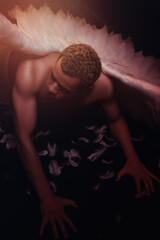 Young strong angel with white wings from heaven. Angel with muscular body. Sensual man