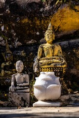 Vertical shot of ancient and worn Buddhism statues in Wat Phiawat, Xiangkhouang, Laos