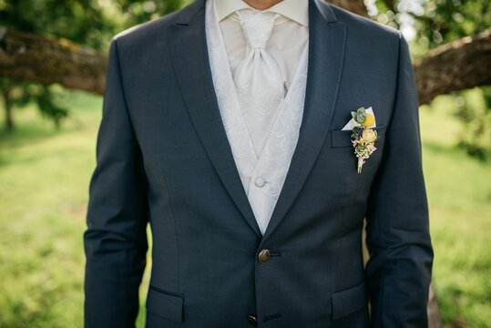 Smartly dressed person at wedding wearing a navy blue suit and a coordinating bow tie