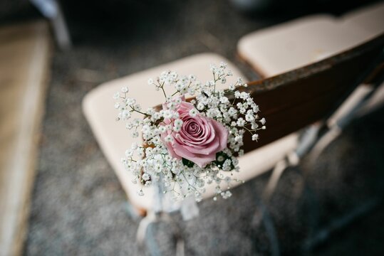 Wooden chair adorned with pink flower and ribbons