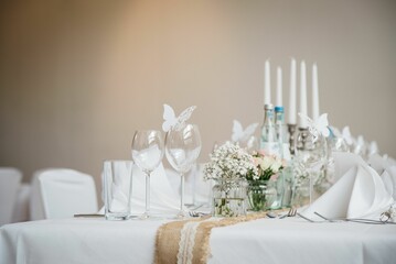 Tastefully decorated table featuring a set of wine glasses and a bouquet of white flowers