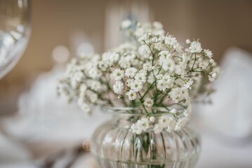 Tastefully decorated table featuring a set of wine glasses and a bouquet of white flowers