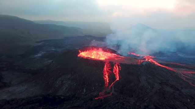 4K Aerial drone footage of Fagradalsfjall active volcano eruption in Geldingadalir, Reykjanes, Iceland. River Of Hot Lava Flowing down the hill surrounded by smoke. Iceland Volcanic eruption Grindavik