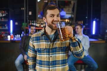 Tasting a good beer. Portrait of thoughtful men drinking beer at the bar