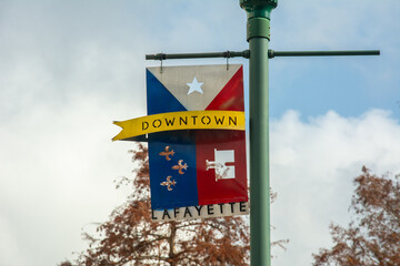 DOWNTOWN LAFAYETTE sign in the form of seal and flag on a street lamp in downtown Lafayette, Louisiana