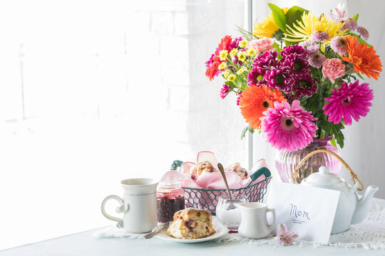 A Mother's Day arrangement with tea, scones and a bouquet of beautiful flowers.
