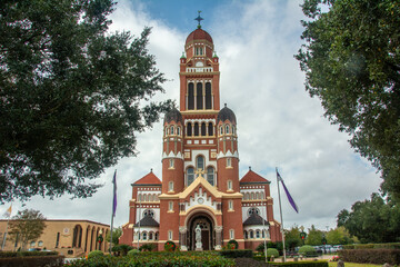 The historic Dutch Romanesque Revival style Cathedral of Saint John the Evangelist or La Cathedrale St-Jean built in 1916 on Cathedral Street in downtown Lafayette, Louisiana, USA - obrazy, fototapety, plakaty