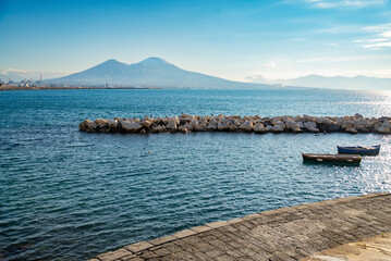 Vesuvius seen and fish boats from the seafront of Naples in Italy