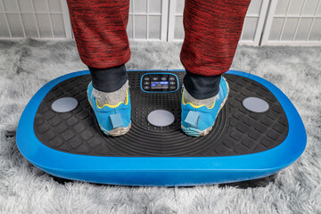 man standing on a vibration plate exercise machine, full body vibration for rehabilitation and recovery - obrazy, fototapety, plakaty
