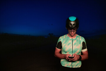 A triathlete using a smartphone while taking a break from a hard night's cycling training
