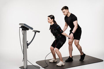 Group workout training in EMS suit, which applies electrical impulses to activate muscles. Trainer...