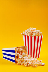 Glass with popcorn on a yellow background