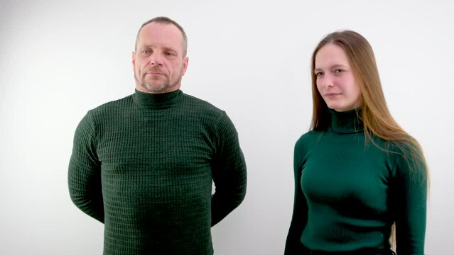 a man and a woman in green clothes on a white background look interview conversation serious people bosses subordinate teacher and student father and daughter a couple of different ages