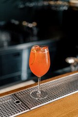 Delicious Aperol spritz cocktail standing on bar counter in restaurant bar waiting for waiter and...