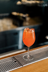 Delicious Aperol spritz cocktail standing on bar counter in restaurant bar waiting for waiter and...