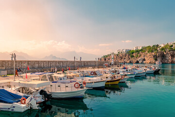 Obraz premium View of a cozy little historical port with turquoise water and boats in the city of Antalya.