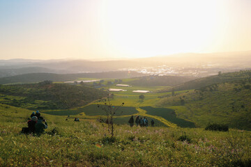 a group of people standing on top of a lush green hillside