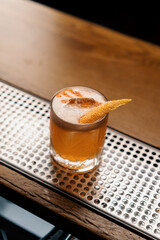 A close-up of the ready-made delicious alcoholic cocktail peach sour stands on the bar and waits...