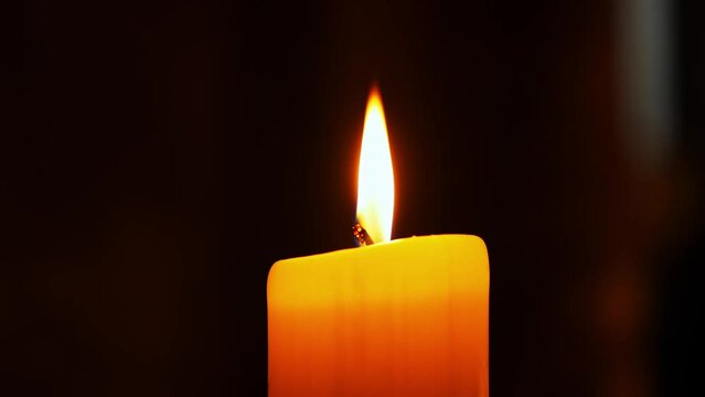 A single  candle burning. Isolated candle burning with dark background.