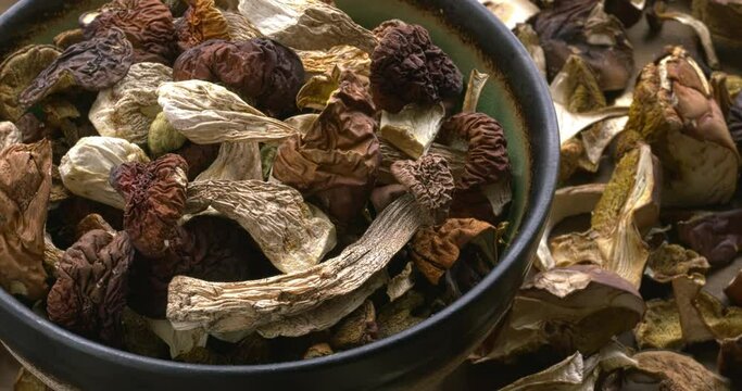 Dried edible forest mushrooms in a bowl. European cuisine ingredient. Table spin.