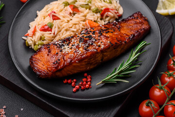 Delicious red salmon fish grilled with sauce and sesame seeds with rice and vegetables