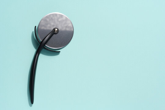 Pizza Cutter With A Black Plastic Handle On A Blue Background