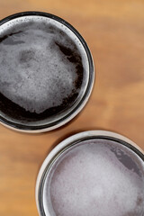 Drinks. Top view of two glasses of beer on the wooden table.	

