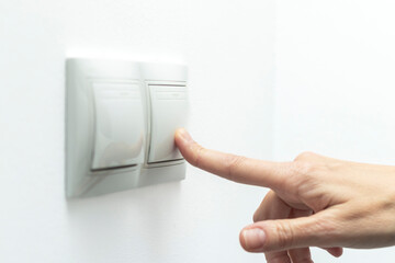 Controlling Technology: Female Hand Turning on an Electrical Switch
