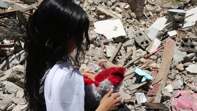 A child from Taiz City sits on the ruins of his ruined home because of the war on city-Yemen.	
