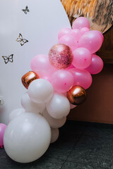 Multi-colored balloons hang on the background of the wall at the girl's children's birthday party. Photography, holiday, photo zone, copy space.
