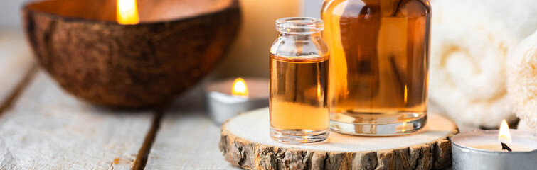 Concept of spa treatment in salon with pure organic natural oil. Atmosphere of relax, detention. Aromatherapy, candles, towel, wooden background. Skin care, body gentle treatment