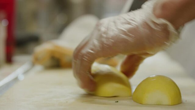 Cutting yellow squash chopping with a knife on cutting board