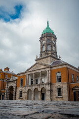 Dublin castle with tower and dome rising up from the courtyard in central Dublin on a cloudy day .Low frog profile photo with majestic building.