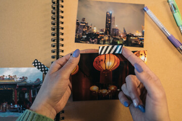 Close-up image of a middle-aged woman's hands picking up a piece of washi tape that she is going to...