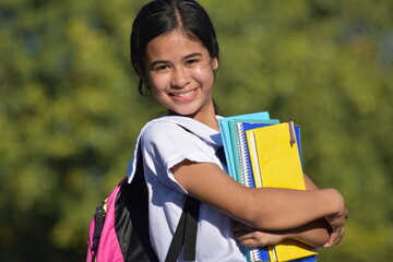 Fototapeta premium Young Filipina Girl Student Smiling Wearing School Uniform Holding Books