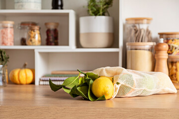 Obraz na płótnie Canvas Fruits in reusable bags on kitchen table. Sustainable, zero waste, healthy lifestyle, personal environmental detox.
