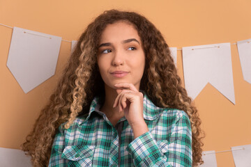 thoughtful young woman to Junina Party in Brazil in beige background. thinking and looking to the side 